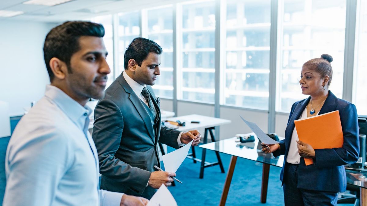 Business professionals discussing documents in a modern office environment.