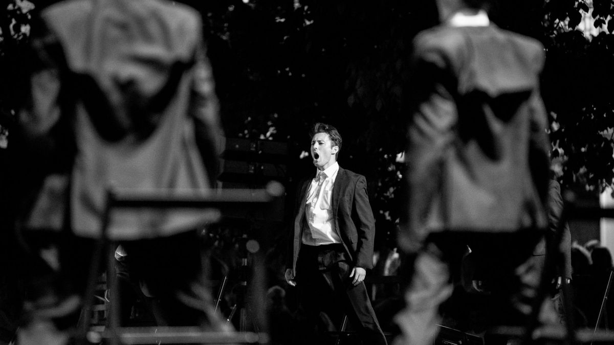 A powerful black and white image of a singer passionately performing on stage.