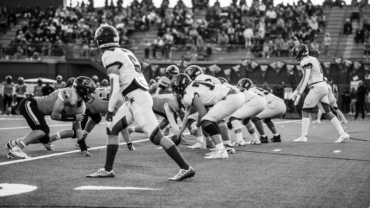 Intense high school football game played in front of spectators, capturing teamwork and energy on the field.