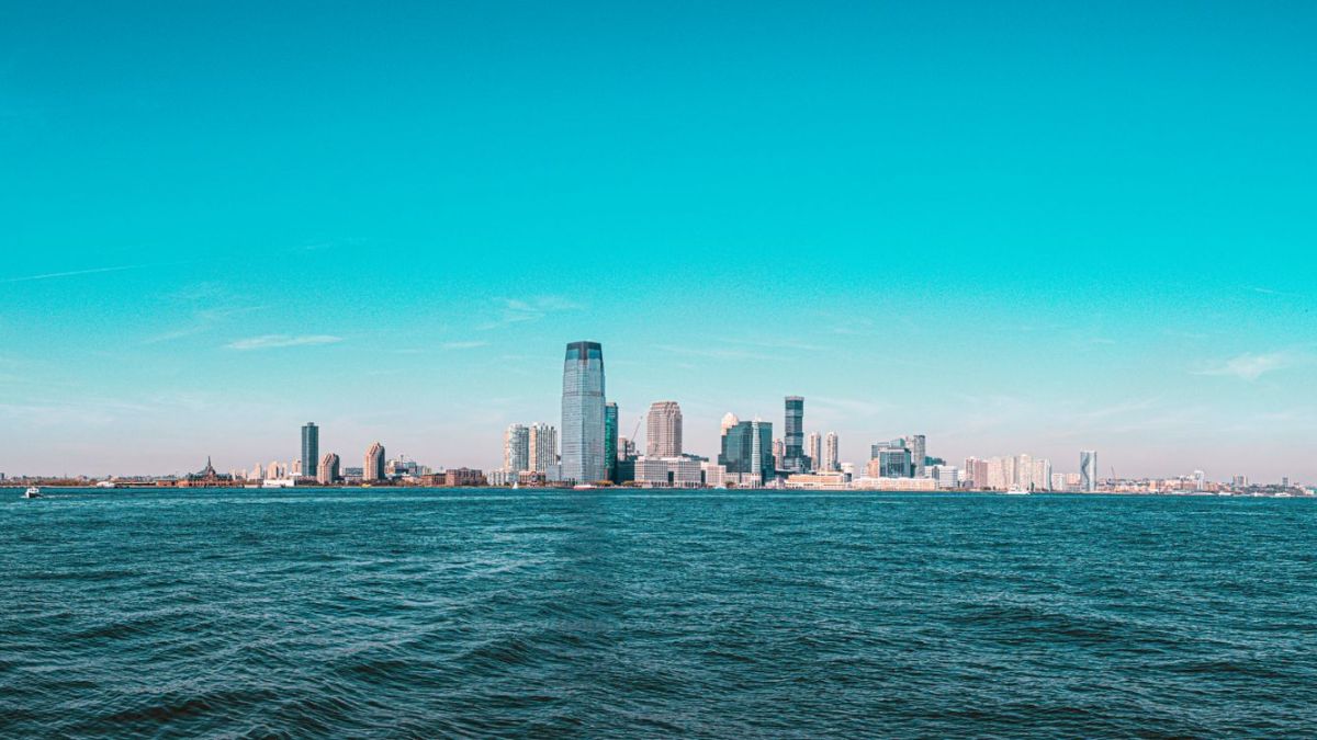 Panoramic view of Manhattan skyline with modern skyscrapers under a clear blue sky.