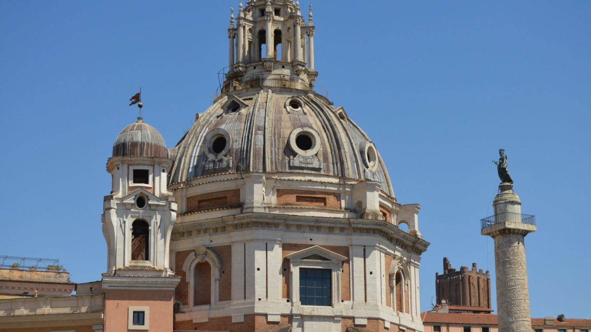 A classical architectural dome in Rome with a column nearby, under a clear blue sky.