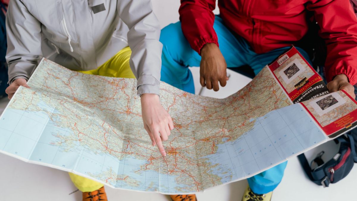 Two travelers examining a detailed map for a winter hiking adventure.