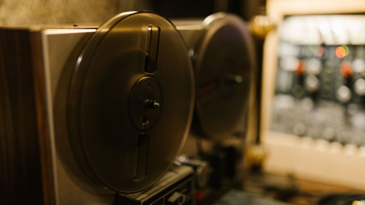 Close-up of a vintage tape recorder in a professional recording studio setting.