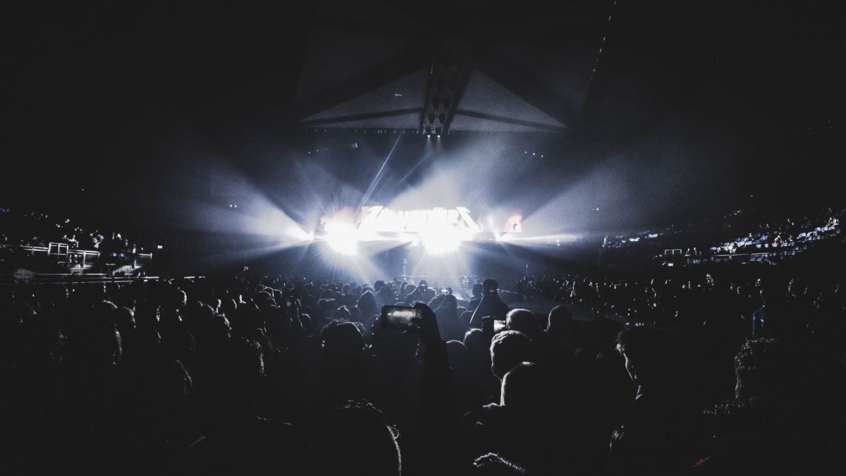 Dynamic concert scene with an energetic crowd at night in a London stadium.