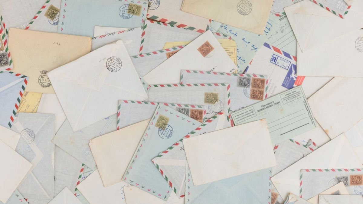 A collection of vintage airmail envelopes and postcards scattered with stamps.