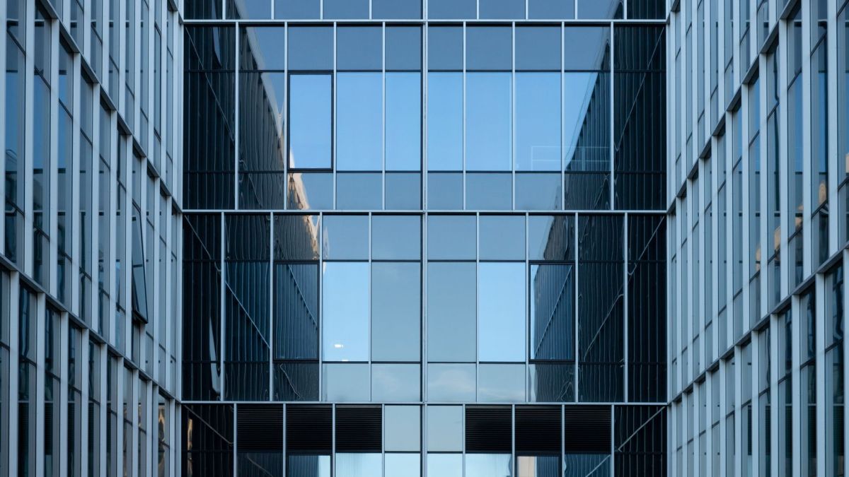 Contemporary building facade with reflective glass windows in an urban environment.