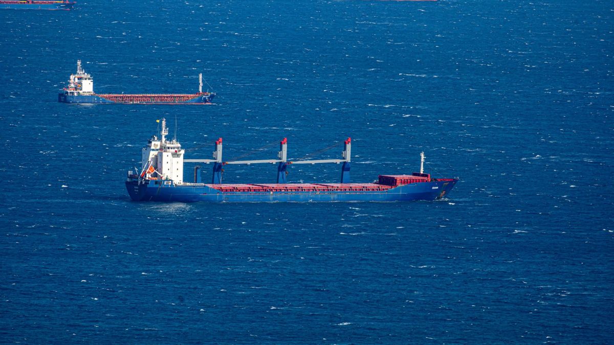 Aerial view of multiple cargo ships navigating through the vast blue ocean, capturing maritime commerce.