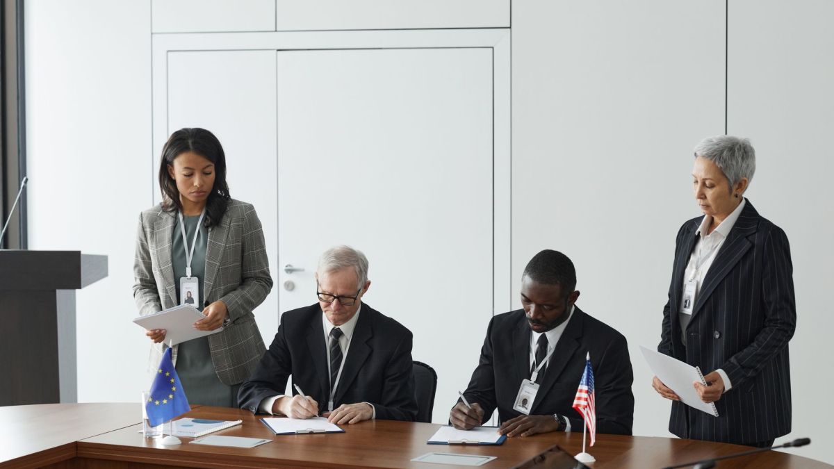 Business leaders signing a significant agreement in a conference room setting.