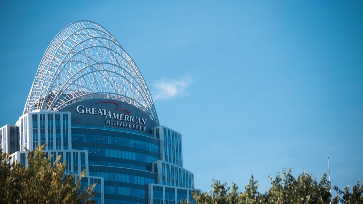 Modern skyscraper, Great American Tower, with arch top set against clear blue sky and foliage in Cincinnati.
