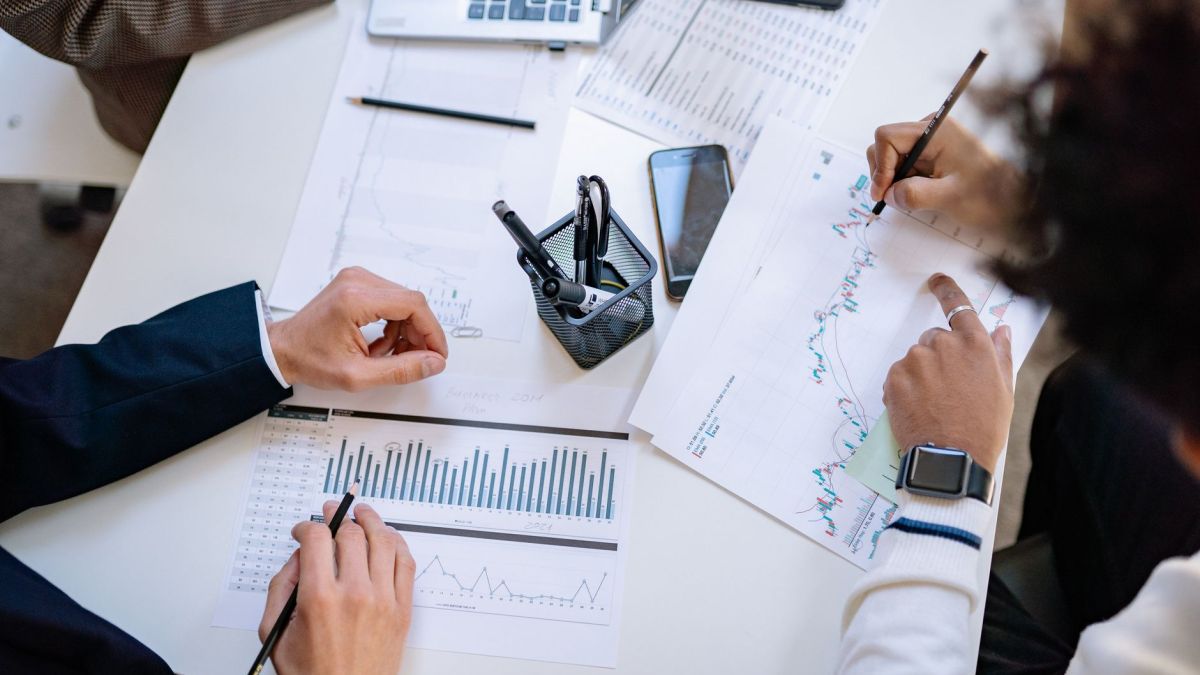 Business team analyzing financial charts and graphs during a collaborative meeting.
