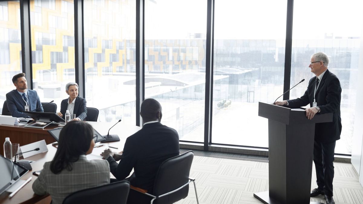Corporate professionals engaged in a formal business meeting in a modern conference room setting.