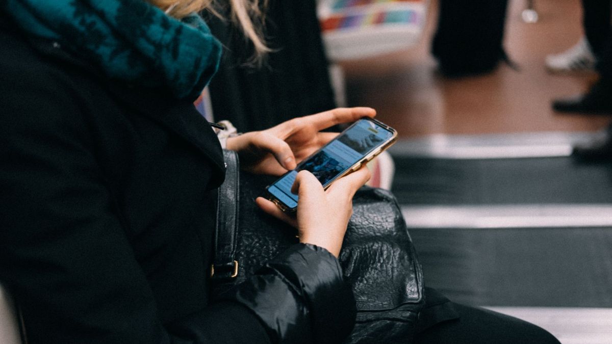 A woman uses her smartphone while commuting on public transportation.