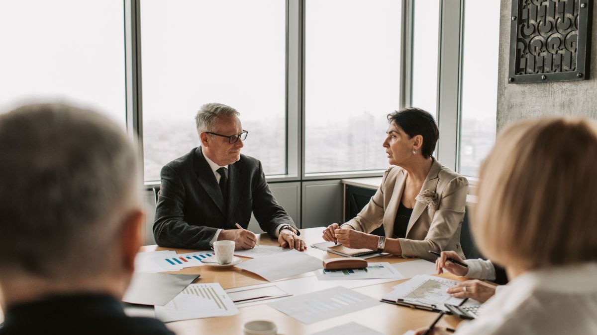 Business professionals engaged in a strategic meeting in a modern office setting with natural light.