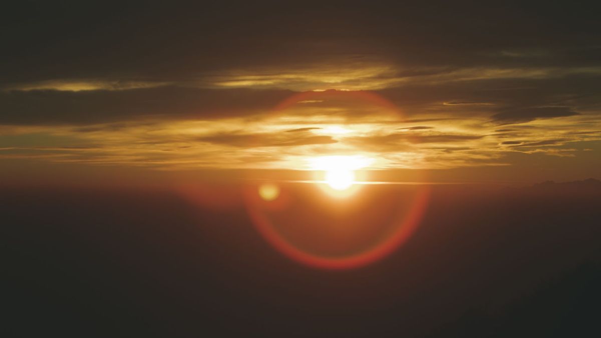 Beautiful sunset with vibrant sun and clouds over Campo dei Fiori, Italy.