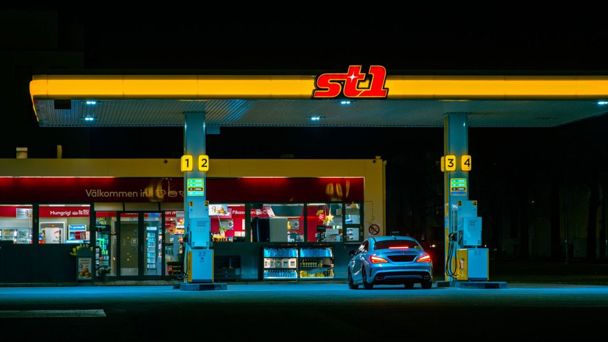 A car refuels at the illuminated St1 gas station in Jönköping, Sweden at night.