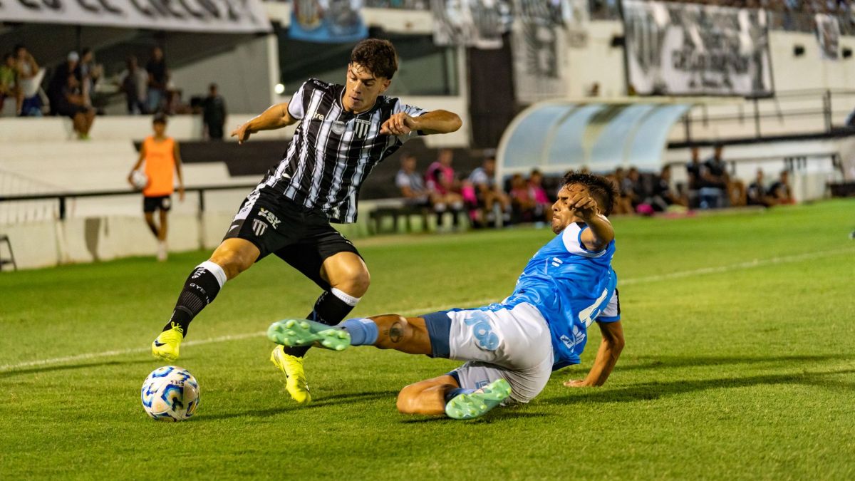A dynamic moment of soccer players tackling under stadium lights during an exciting match.