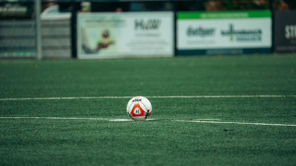 A detailed shot of a soccer ball on a lush green field, perfect for sports-related themes.