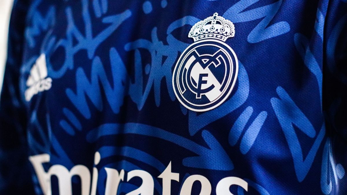 Close-up view of a blue Real Madrid soccer jersey featuring the team's logo and design elements.