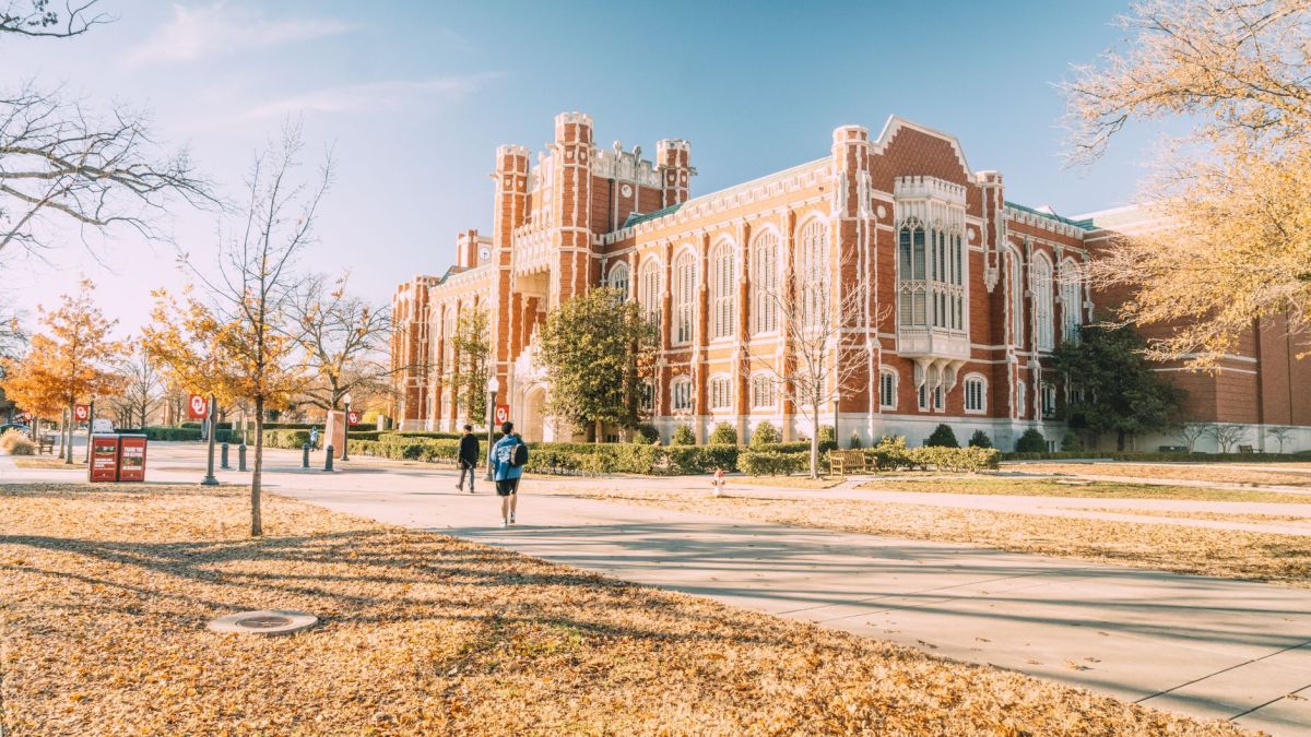 A scenic view of a historic university building surrounded by autumn foliage, reflecting academic architecture.