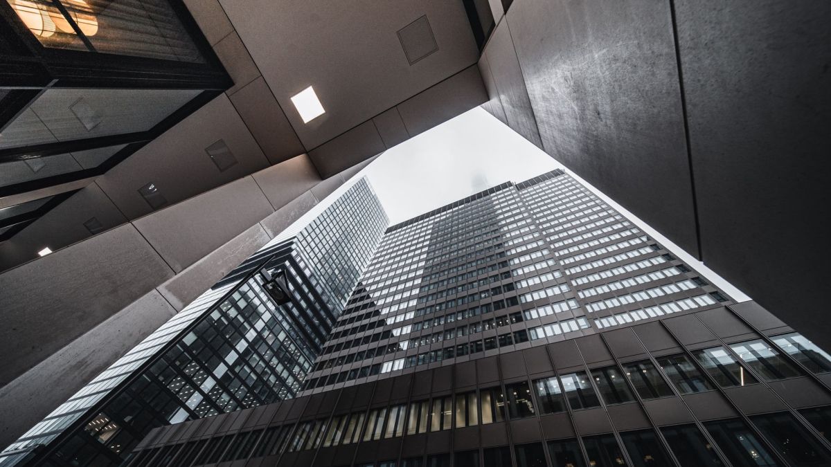 Low-angle view of modern skyscrapers with glass facades in an urban environment.