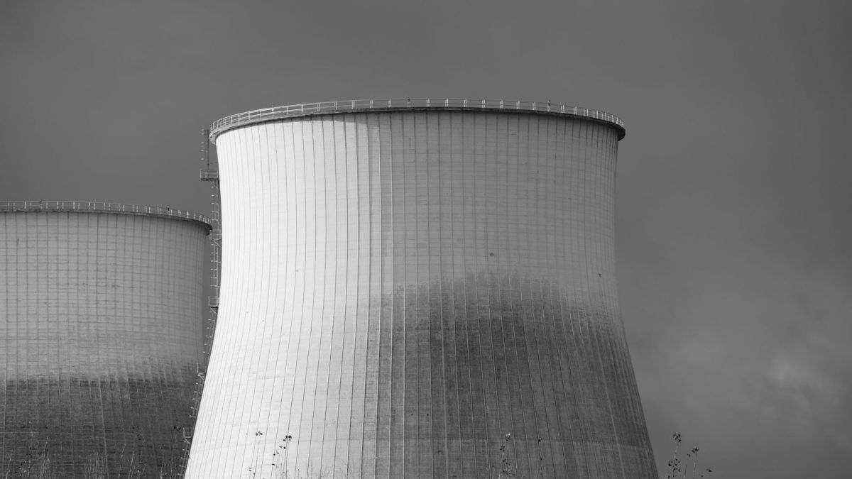 Elegant black and white depiction of cooling towers at a nuclear power station, symbolizing energy and industry.