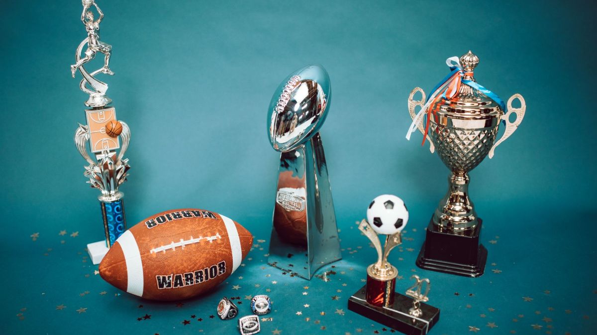A collection of sports trophies and memorabilia representing achievement and success on a blue background.