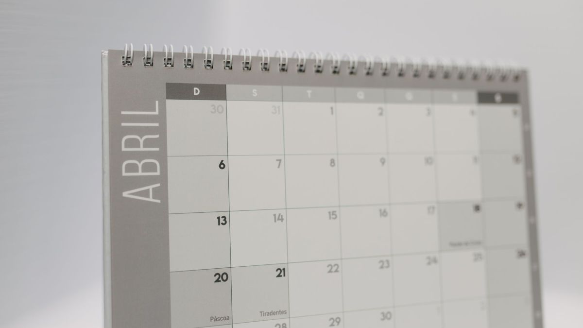 Close-up of a spiral-bound April desk calendar with a gray minimalistic design.