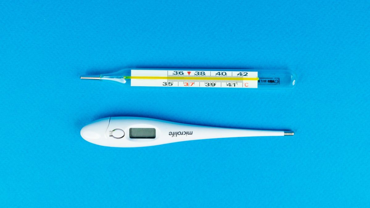 Digital and mercury thermometers on blue background for medical concept.