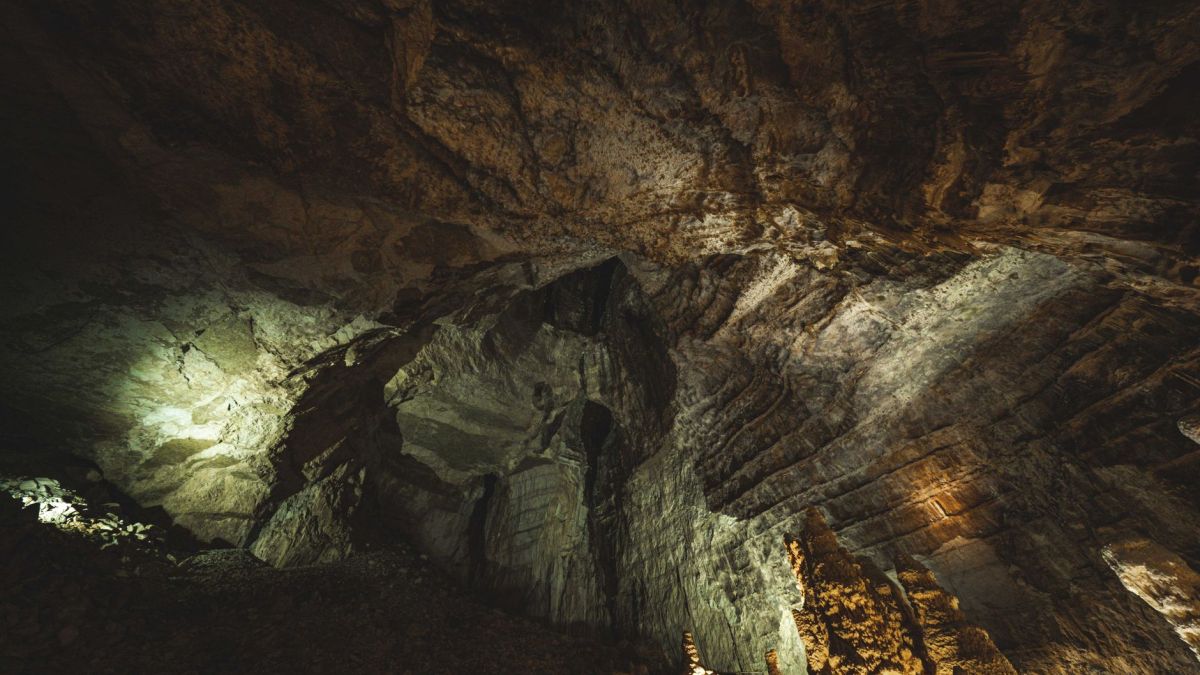 Explore the depth and textures of a dramatic underground cave with intricate rock formations.